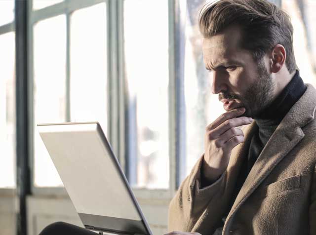Man looking pensively at a laptop
